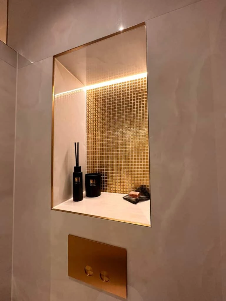 Ingebouwde nis met gouden mozaïek, verlichting en bijpassende toiletbediening